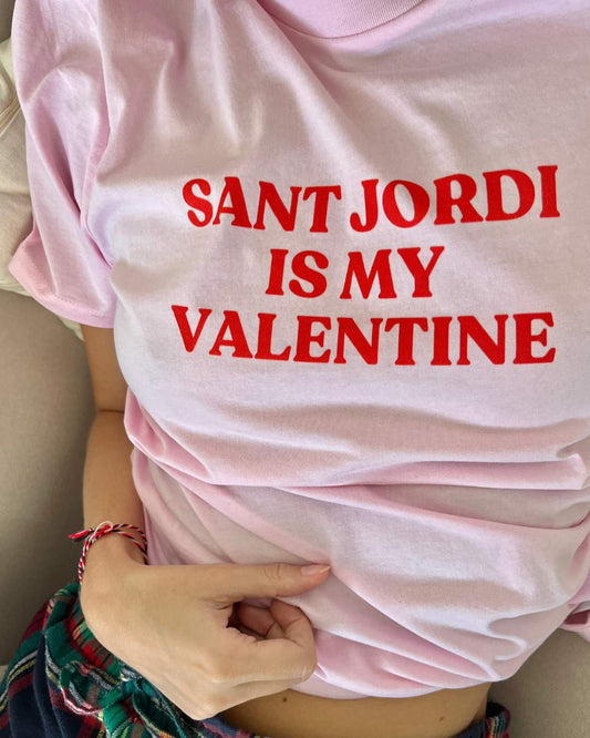 Samarreta rosa pastís amb la frase "SANT JORDI IS MY VALENTINE" en vermell, disseny minimalista de Catalan Words, perfecta per celebrar Sant Jordi.