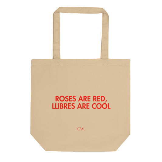 Tote bag de cotó orgànic amb el text "ROSES ARE RED LLIIBRES ARE COOL" imprès en vermell sobre fons neutre, disseny minimalista de Catalan Words ideal per Sant Jordi.