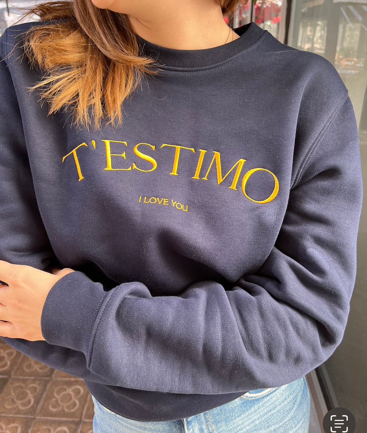 Dessuadora unisex amb el text "T'ESTIMO" brodat en minimalista, disseny elegant de Catalan Words que han lluït influencers com Laura Escanes i Dulceida.
