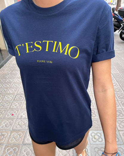 Samarreta blava amb el text "T'ESTIMO" en groc, disseny minimalista de Catalan Words.
