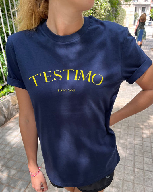 Samarreta blava amb el text "T'ESTIMO" en groc, disseny minimalista de Catalan Words.
