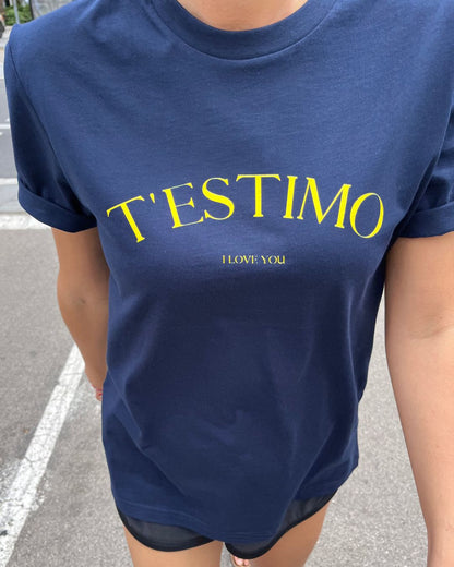Samarreta blava amb el text "T'ESTIMO" en groc, disseny minimalista de Catalan Words.
